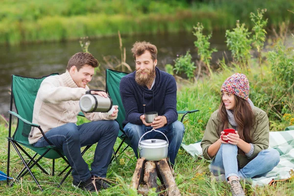 Groupe de touristes souriants cuisiner des aliments dans le camping — Photo