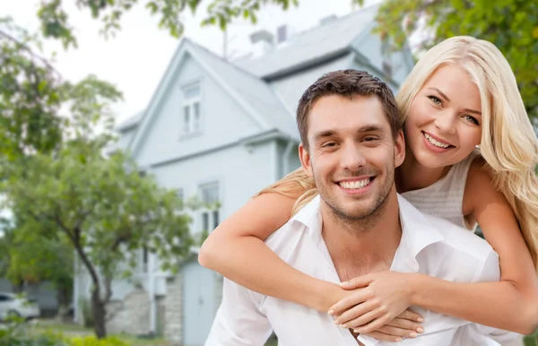 家の背景に抱いて笑顔のカップル ロイヤリティフリーのストック写真