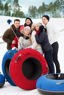 group of smiling friends with snow tubes clipart