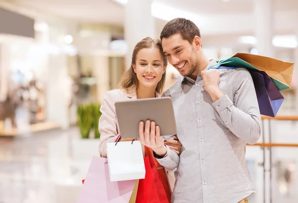 Par med TabletPC och påsar i gallerian — Stockfoto