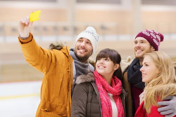 Amici felici prendendo selfie sulla pista di pattinaggio — Foto Stock