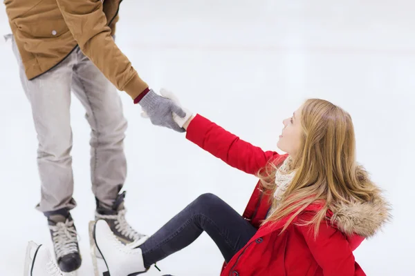 Homme aidant les femmes à se lever sur la patinoire — Photo