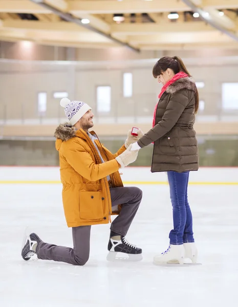 Feliz pareja con anillo de compromiso en pista de patinaje —  Fotos de Stock