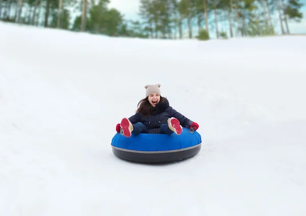 Gelukkig tienermeisje glijdend van op sneeuw tube — Stockfoto