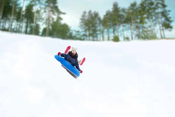 Menina adolescente feliz deslizando para baixo no tubo de neve — Fotografia de Stock