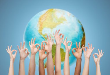 human hands showing ok sign over earth globe clipart