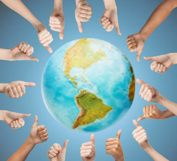 Human hands showing thumbs up in circle over earth — Stock Photo, Image