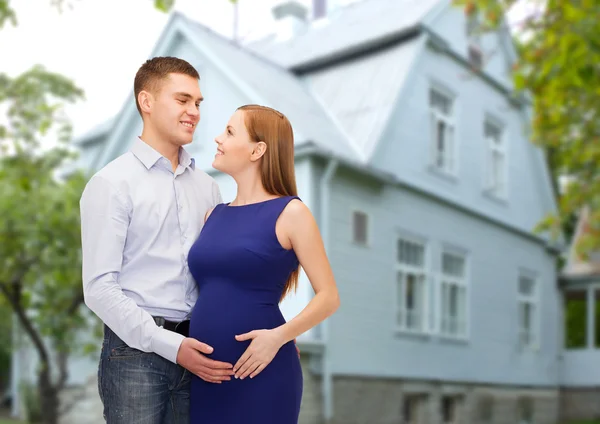 Feliz joven familia esperando niño sobre casa —  Fotos de Stock