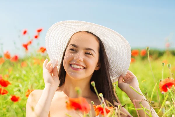 微笑在草帽上罂粟花田里的年轻女子 — 图库照片