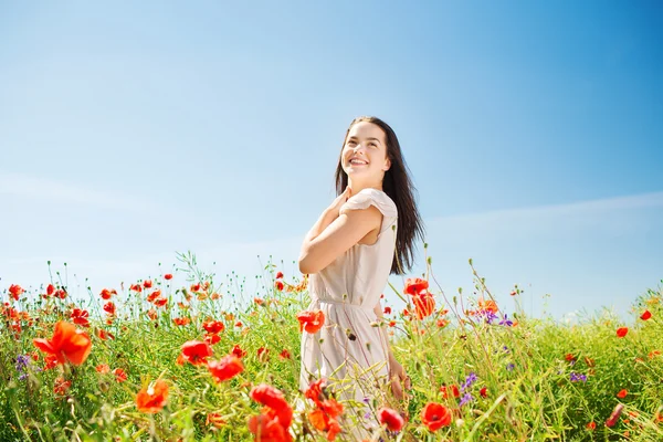 ケシ畑に笑顔の若い女性 — ストック写真