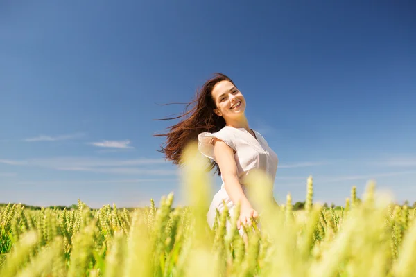 Lächelnde junge Frau auf einem Getreidefeld — Stockfoto