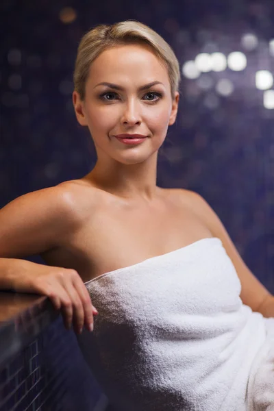 Hermosa joven sentada en toalla de baño — Foto de Stock