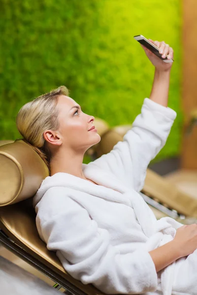 Beautiful young woman with smartphone at spa — Stock Photo, Image