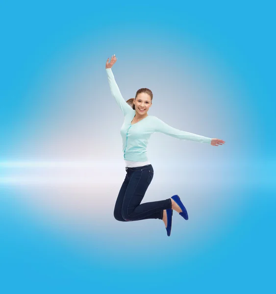Lächelnde junge Frau springt in die Luft lizenzfreie Stockfotos