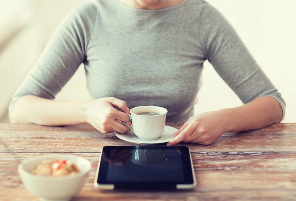 Kobieta pije kawę i przy użyciu komputera typu tablet — Zdjęcie stockowe