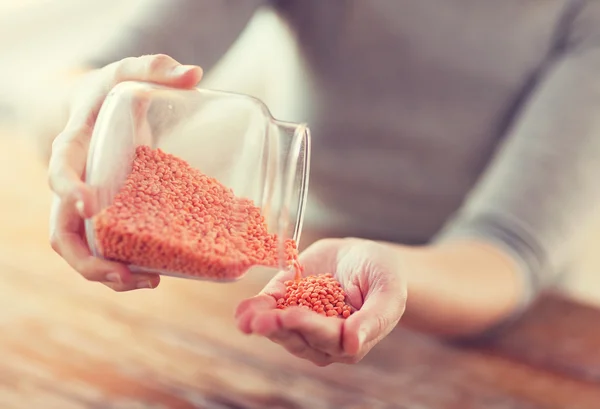 Primo piano del vaso di svuotamento femminile con lenticchie rosse — Foto Stock