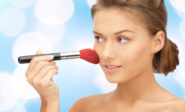 Schöne lächelnde Frau mit Make-up Pinsel — Stockfoto