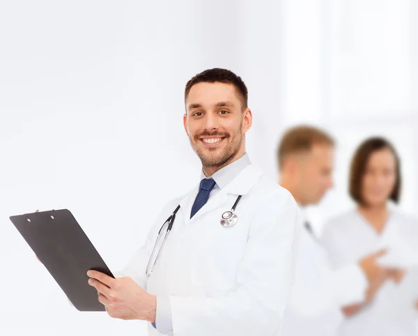 Sorridente médico masculino com prancheta e estetoscópio — Fotografia de Stock