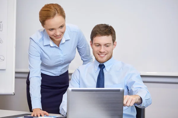 Glimlachende zakenmensen met laptop in office — Stockfoto