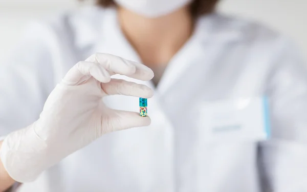 Закрытие ученого, держащего таблетку в лаборатории — стоковое фото