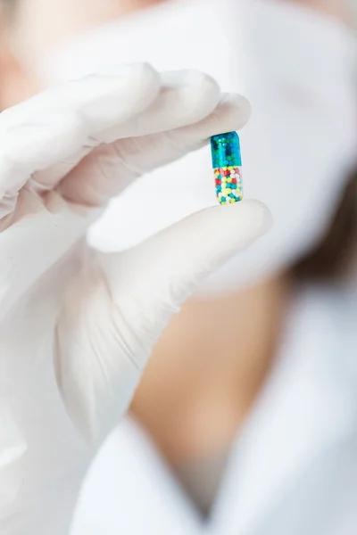 Perto de cientista segurando pílula em laboratório — Fotografia de Stock