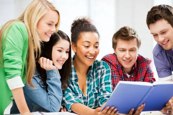 Estudiantes leyendo libro en la escuela — Foto de Stock