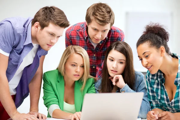 Internationale studenten kijken naar laptop op school — Stockfoto