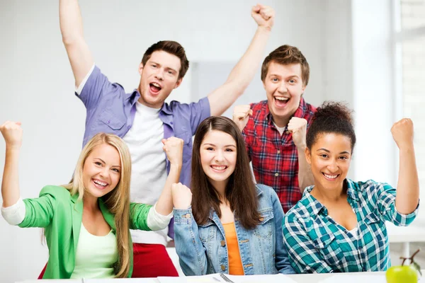 Students holding hands up at school — Stock Photo, Image