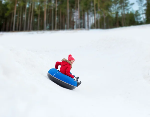 Menina adolescente feliz deslizando para baixo no tubo de neve — Fotografia de Stock