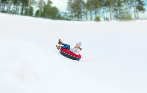 Felice ragazza adolescente scorrevole giù sul tubo della neve — Foto Stock