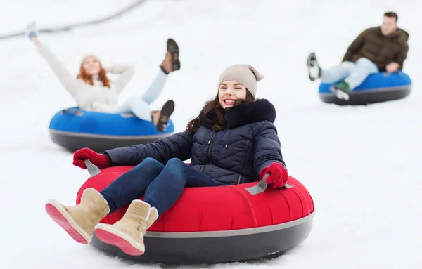 雪のチューブの上を滑り幸せな友人のグループ — ストック写真