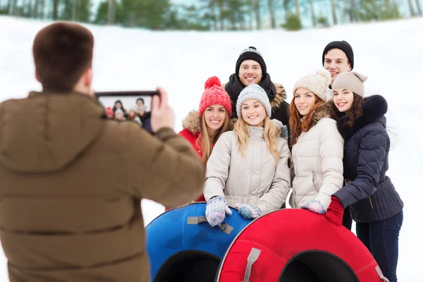 Grupo de amigos sonrientes con tubos de nieve —  Fotos de Stock