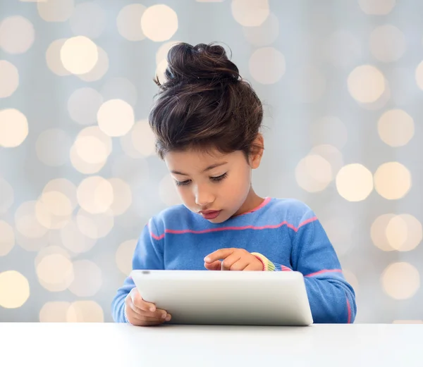 Petite fille avec tablette pc sur fond de lumières — Photo