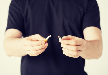 man breaking the cigarette with hands clipart