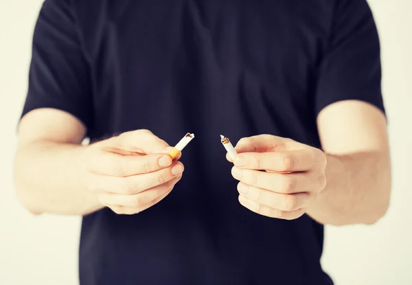 Hombre rompiendo el cigarrillo con las manos — Foto de Stock