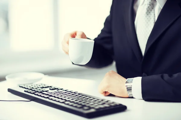 Man hands with keyboard drinking coffee — Stock Photo, Image