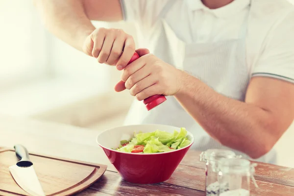 Primo piano di mani maschili insalata aromatizzante in una ciotola — Foto Stock