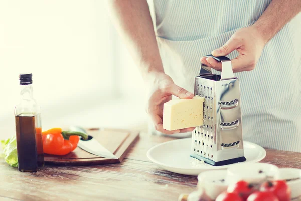 Close up of male hands grating cheese — Stock Photo, Image