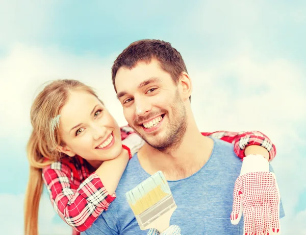 Casal sorridente coberto com tinta com pincel — Fotografia de Stock