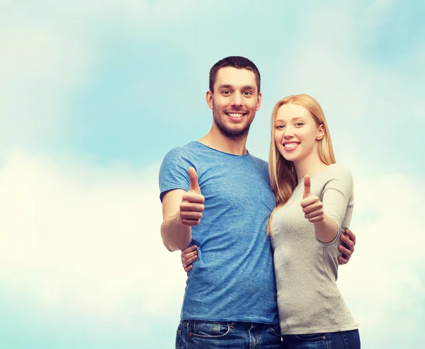 Sonriente pareja mostrando pulgares hacia arriba — Foto de Stock