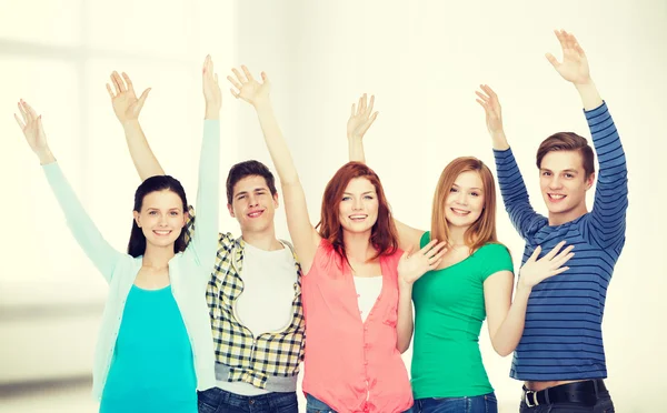 Grupp leende studenter viftande händer — Stockfoto