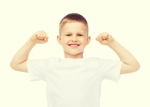Little boy in blank white t-shirt showing muscles — Stock Photo, Image