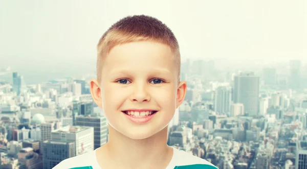 Улыбающийся маленький мальчик на зеленом фоне — стоковое фото