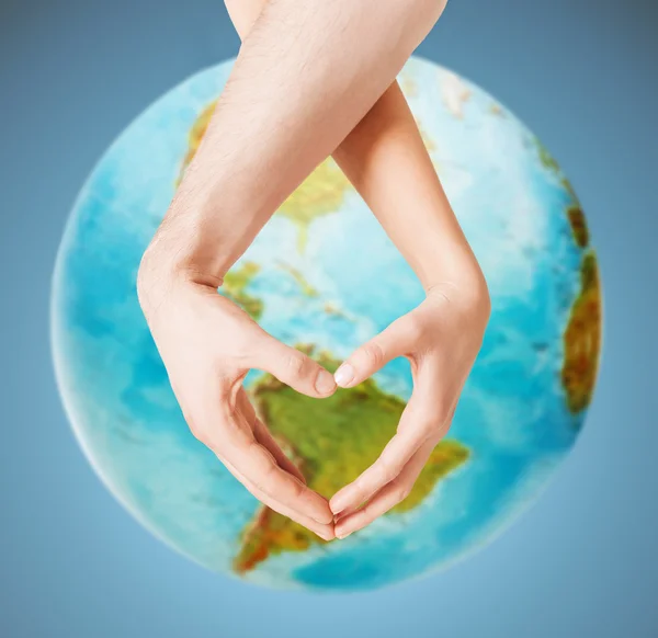 Human hands showing heart shape over earth globe — Stock Photo, Image