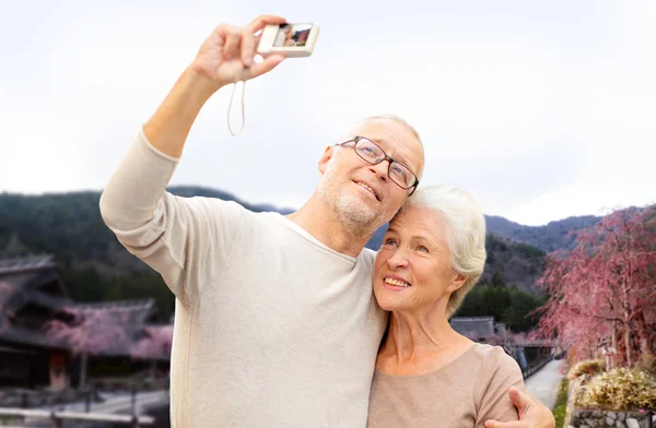 Senior couple with camera over asian village — Stock Photo, Image