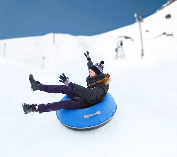 Feliz joven deslizándose hacia abajo en el tubo de nieve —  Fotos de Stock