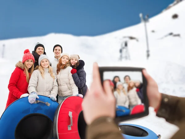 Amigos sonrientes con tubos de nieve y tableta PC —  Fotos de Stock