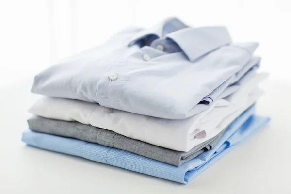 Close up of ironed and folded shirts on table — Stock Photo, Image