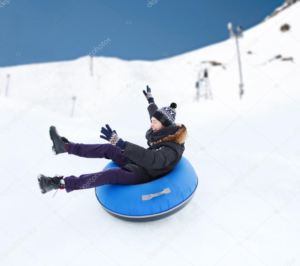 Happy young man sliding down on snow tube Stock Photo by ©Syda_Productions  63933135