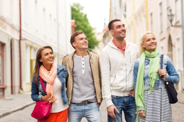 group of smiling friends walking in the city clipart